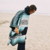 Man on beach in sustainable Baja Aqua quick dry Poncho Towel
