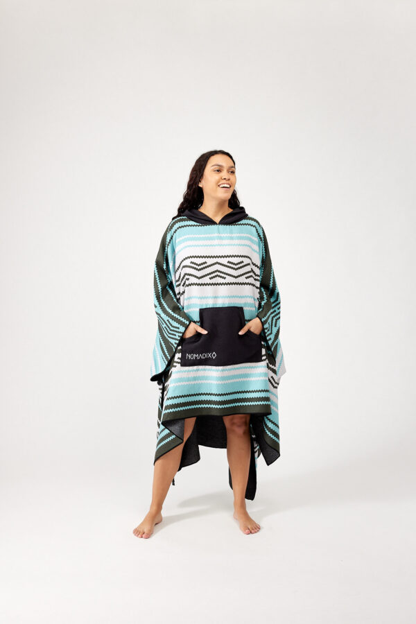 Woman with hands in front pocket of one-size, quick dry Baja Aqua Poncho Towel