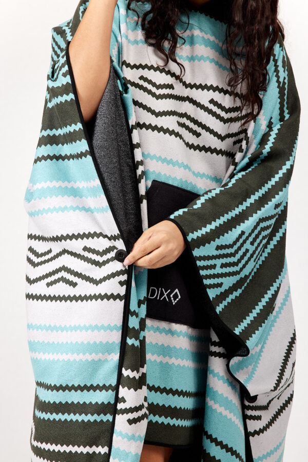 Woman buttoning side of recycled Baja Aqua Poncho Towel for swim, beach, scuba and travel