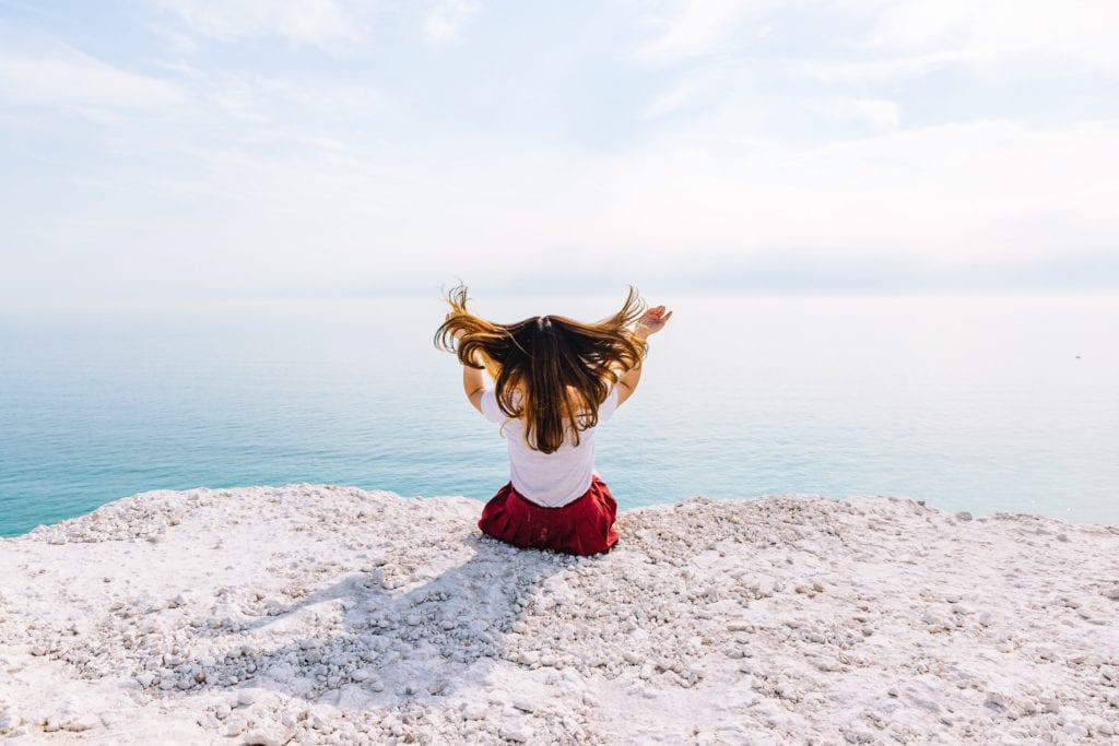 Woman in front of the ocean flinging her hair