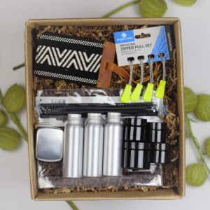 Sustainable travel accessory gift box set with travel containers, zip pulls and luggage tag