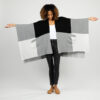 Woman showing full arms outstretched view of organic cotton, one size travel wrap in black and grey colorblock