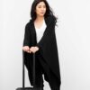 Asian woman traveler in black organic cotton travel blanket wrap from Zestt Organics