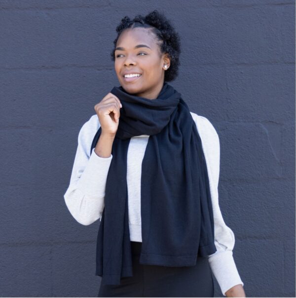 Person in black organic cotton scarf for sustainable travel and fasion