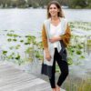 Woman enjoying autumn weather while wearing her Organic Cotton Travel Scarf in bronze colorblock, by Zestt Organics