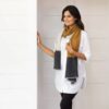 Woman standing against a white backdrop wearing her Organic Cotton Travel Scarf in bronze colorblock, by Zestt Organics