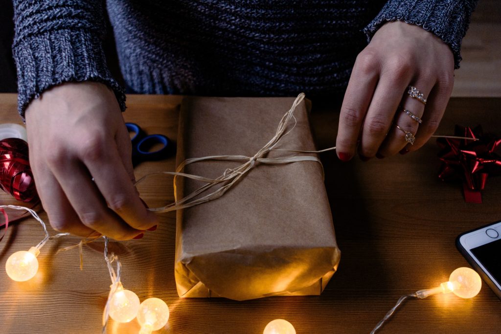 Hands tying string on sustainable gift wrapping paper and string.