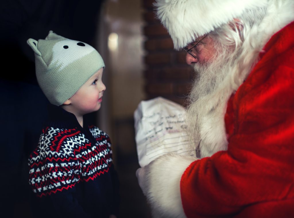 Young boy with Santa wishing for a sustainable Christmas