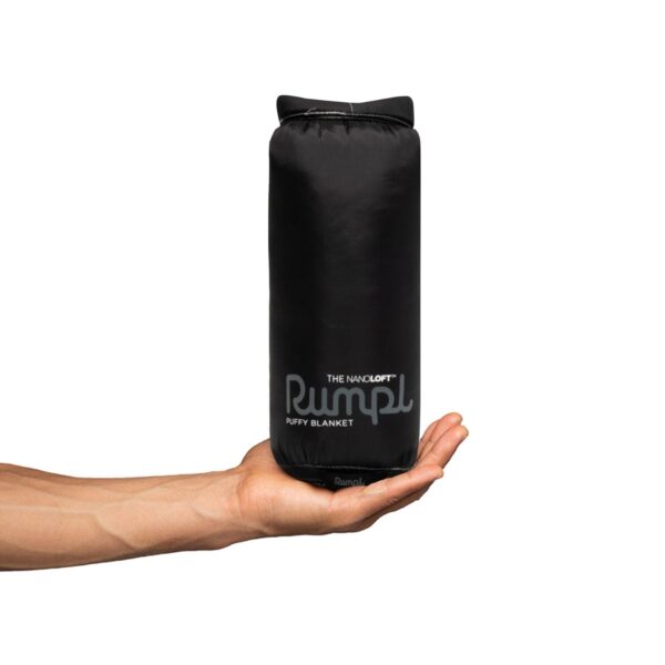 The pack sack for the Nanoloft Travel Blanket by Rumpl is small and can easily fit in one hand.
