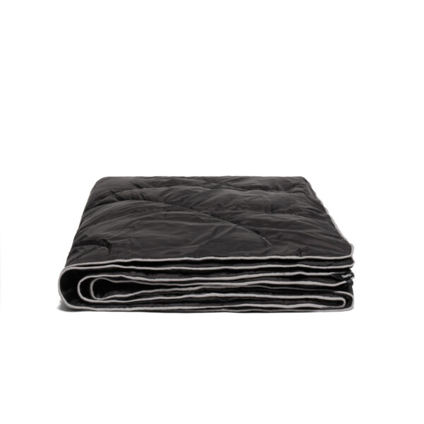 The Nanoloft Puffy Travel Blanket by Rumpl, shown in black with light grey edging. This blanket is made from the same technical materials as sleeping bags and insulated jackets.