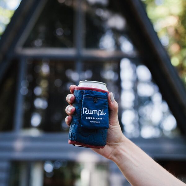 The Beer Blanket slash Koozie by Rumpl is great for keeping your hands warm and your drink cold and is made from 100% recycled materials. Shown in deepwater blue.