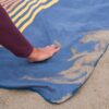 The earth friendly stash mat by Rumpl is made from recycled materials and is stain, sand, and odor resistant and has a waterproof bottom.