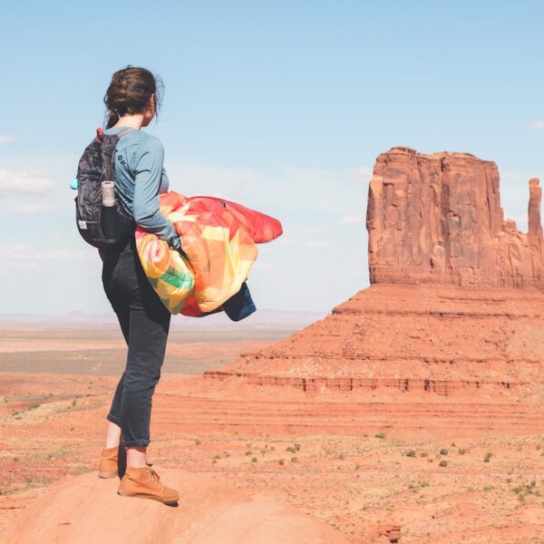 A model hiking in Utah while carrying her Original Puffy Blanket by Rumpl in her hands; it is light and easy to carry.