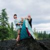 A family taking a break while on a hike. One of the kids is using the Original Puffy Blanket by Rumpl as a blanket slash cape.