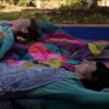 Women laying on Chromatic Voyage eco-friendly, recycled puffy blanket