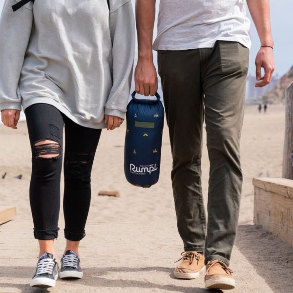 Couple at beach carrying sustainable Outdoor Vibes down-alternative blanket in bag