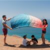Family at beach with Patina Pixel recycled, down-alternative blanket from Rumpl