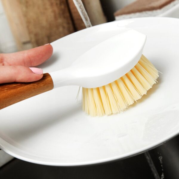 Eco friendly recycled plastic and bamboo dish cleaning brush from Full Circle cleaning a dish