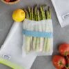 Asparagus and vegetables in recycled plastic, reusable produce bags from Full Circle Home for eco-friendly shopping