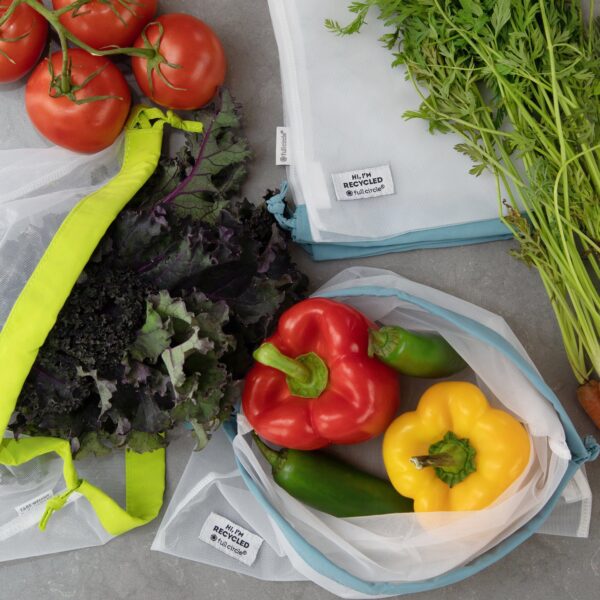 Vegetables in set of recycled plastic, reusable produce bags for eco-friendly grocery shopping