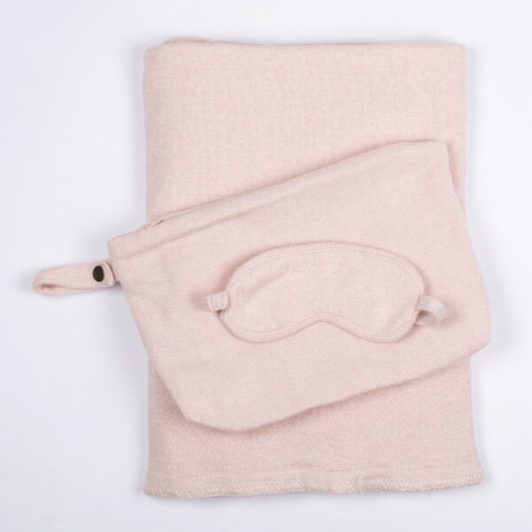 The Organic Cotton Travel Set by Zestt Organics, shown in blush, comes with a knit throw, eye mask, and carrying pouch.