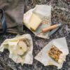 The 3 pack of eco-friendly Bee's Wrap food wraps comes in three different sizes, small, medium, and large. Shown here wrapping up someone's lunch of granola, apple, and cheese.