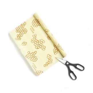 Beeswrap brand food wraps are now available in a larger format with the honeycomb wrap roll. Photo shows a roll of food wrap with a pair of scissors, indicating that the customer can cut her desired size of food wrap.