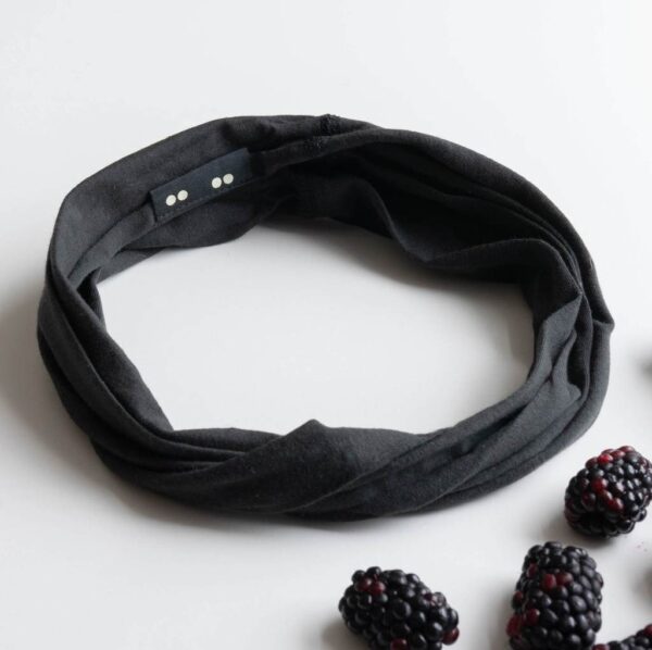 A Kooshoo twist headband shown in raven black; made from organic cotton and locally dyed, cut, and sewn in a fair trade certified Los Angeles facility