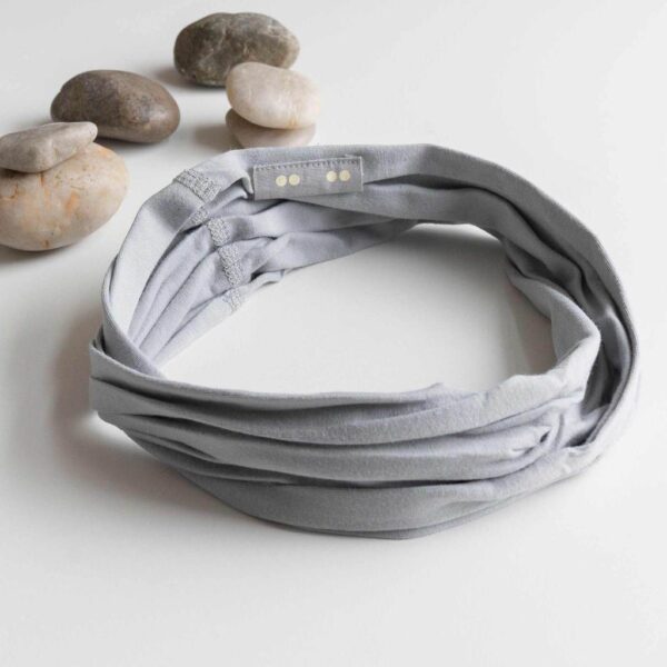 A Kooshoo twist headband shown in grounding gray; made from organic cotton and locally dyed, cut, and sewn in a fair trade certified Los Angeles facility