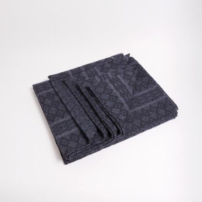 The Peruvian recycled cotton blanket by Manduka features a beautiful gray diamond pattern and is made from mostly recycled materials.