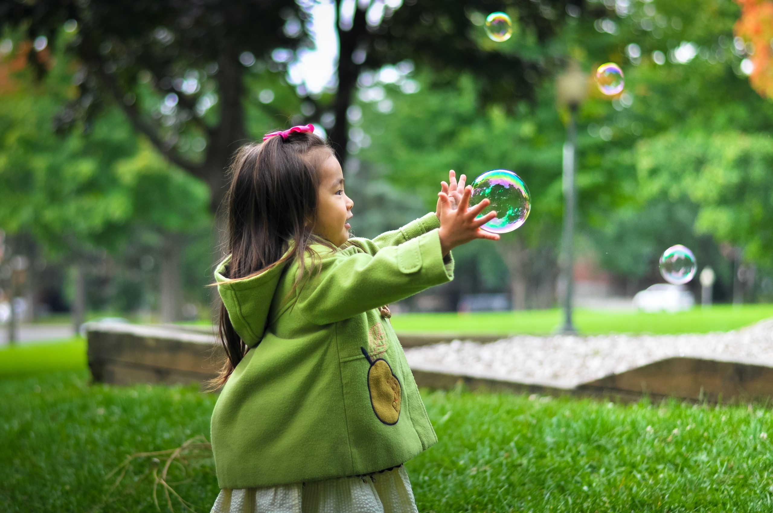 Young Asian girl with a bubble outside