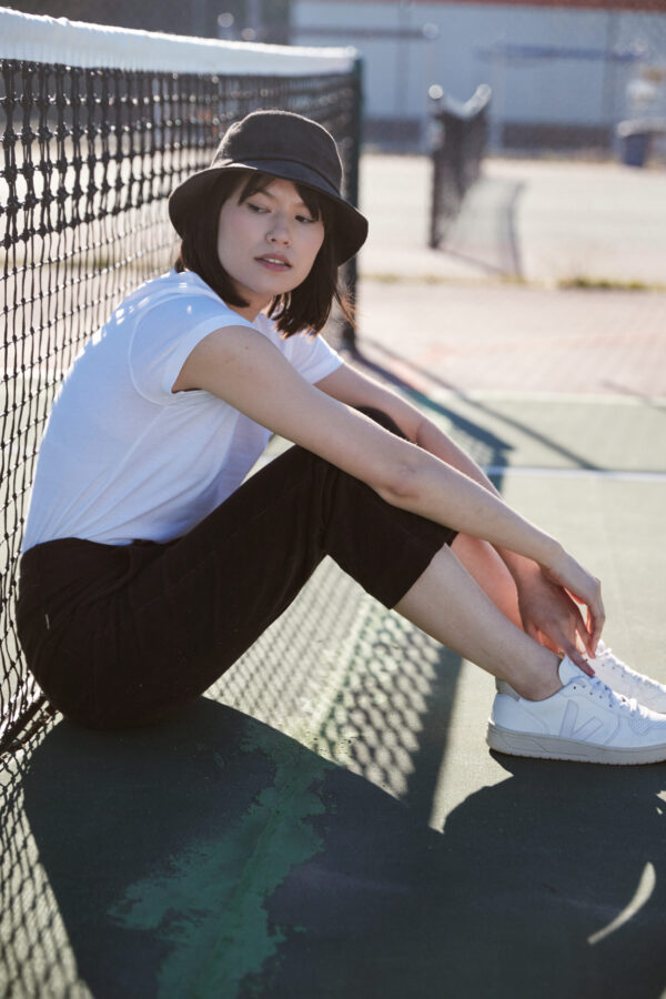 Female wearing black organic cotton travel bucket hat from tentree