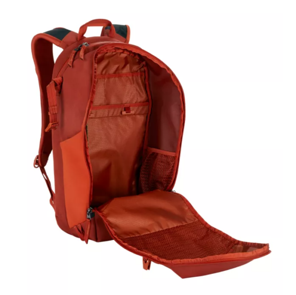 Photo shows the sustainably made Explore 26L backpack by Eagle Creek zipped open to reveal an interior with padded laptop compartment and other internal pockets; shown here in midnight sun red.
