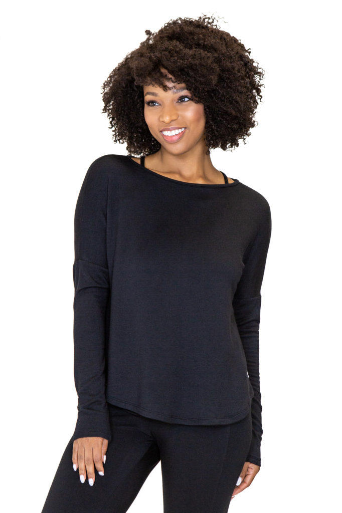 Model is wearing a black pullover made from eco-friendly French Terry fabric, by brand JJWinks. Made in USA, this pullover is carbon neutral.