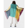 The artisanal cape infinity by fifth origins is woven in a color block pattern, shown here in rainbow colors. Each cape is sustainably made using 100% organic Himalayan wool.