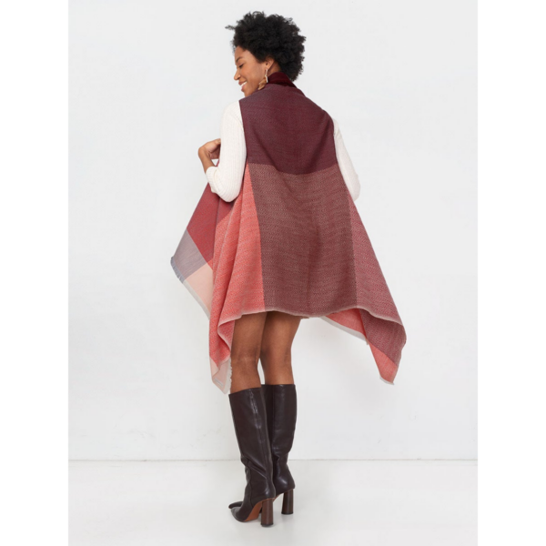 A model is wearing tall boots and an Infinity Cape by Fifth Origins in Tulip. The beautiful color block wool is eco-friendly, organic, and sustainable.