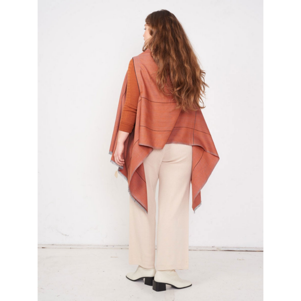 The eco-friendly Artisanal Cape Infinity Lite, modeled here in spice, is made from 100% organic Himalayan wool and is woven by women artisans in India.