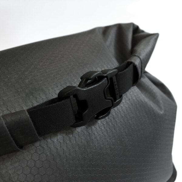 Close up of the FlatPak waterproof toiletry case by matador, showing the Cordura ripstop fabric and sturdy rolltop buckle. This bag has a 2 liter max, but can roll up to be a smaller bag as needed.