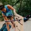 Woman picking up portable, camping table made from sustainable bamboo