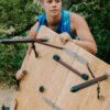 Woman picking up portable, camping table made from sustainable bamboo