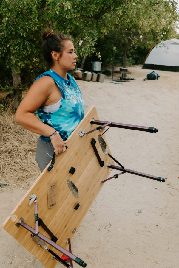 Woman carrying sustainable, bamboo and aluminum foldable travel table