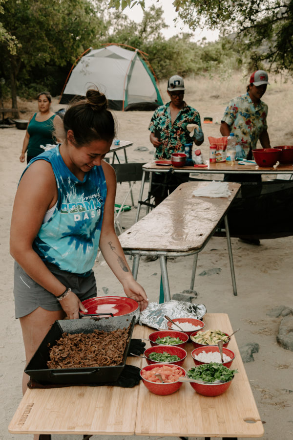 Woman serving food at campground from bamboo foldable travel table
