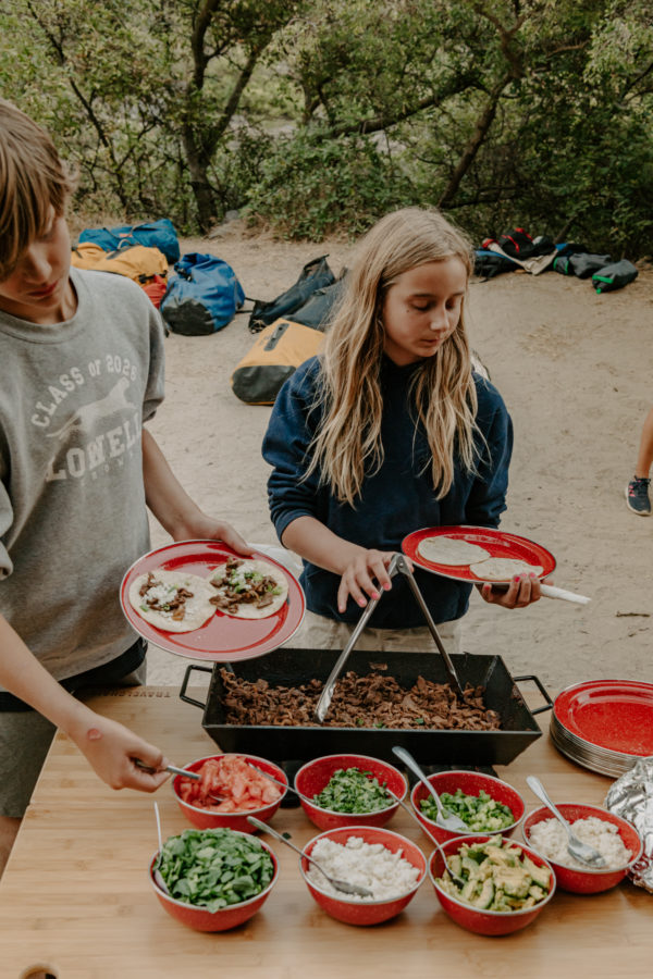 Kids serving food from collapsible, travel and camping bamboo and aluminum table