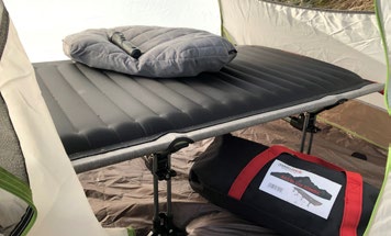 View of Airtite foldable travel cot in camping tent with carry bag