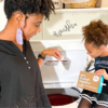 Woman and her child putting eco-friendly laundry detergent sheet in the top-load washer