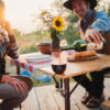 Couple pouring wine for picnic on portable bamboo travel table