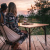 Couple drinking wine at sunset on portable bamboo travel table