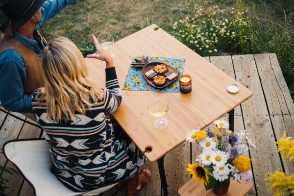 Woman sitting for picnic on foldable, bamboo travel table