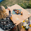 Woman sitting for picnic on foldable, bamboo travel table