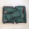 Overhead view of recycled, green packing cubes in carry on suitcase for sustainable travel